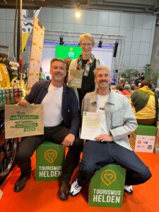 Drei Mitglieder der Free Walking Tour Chemnitz zeigen stolz ihre Auszeichnung