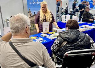 Antje Rennack im Gespräch mit zwei Rollstuhlfahrenden